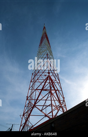 Ein monolithischer rote und weiße Stahl Kommunikationssystem mit Satellitenschüssel an der Spitze erhebt sich hoch in eine tiefe Perspektive gegen Stockfoto