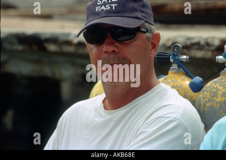 Ein bebrillter Mann mittlerer Alter tragen eine schwarze Baseballkappe entspannt gegen Panzer verwendet zum Tauchen Stockfoto