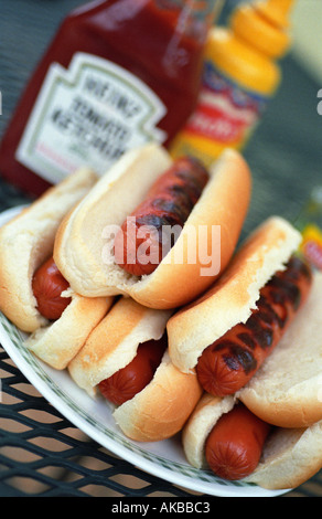 Haufen von Hotdogs mit Ketchup und Senf im Hintergrund Stockfoto