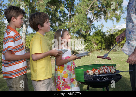 Vater Speisen vom Grill für Kinder (5-11) im Einklang, close-up Stockfoto