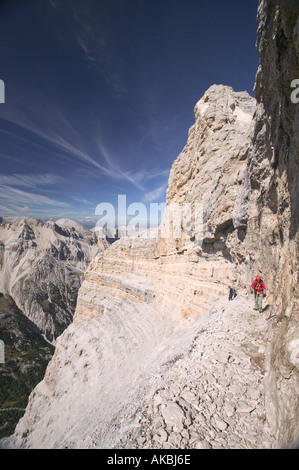 Kletterer, die Überquerung auf einem Felsvorsprung über ein extrem exponierten Felsen-Abschnitt auf der Strecke G Lipella Klettersteig Tofana de Rozes Stockfoto