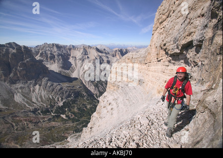 Kletterer, die Überquerung auf einem Felsvorsprung über ein extrem exponierten Felsen-Abschnitt auf der Strecke G Lipella Klettersteig Tofana de Rozes Stockfoto