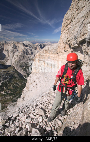 Kletterer, die Überquerung auf einem Felsvorsprung über ein extrem exponierten Felsen-Abschnitt auf der Strecke G Lipella Klettersteig Tofana de Rozes Stockfoto