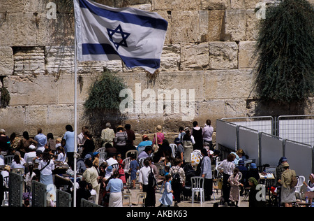 Religiöse Juden beten an der Klagemauer mit der israelischen Flagge im Vordergrund Stockfoto