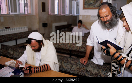 Jüdischen Mann und der Junge in traditioneller Kleidung Lesen der Thora mit Tefillin, Israel, Naher Osten Stockfoto