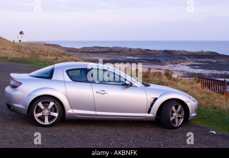 Mazda RX8 Sportwagen geparkt in der Nähe von Hirsch Rock Leuchtturm in Bamburgh Nothumberland England Stockfoto