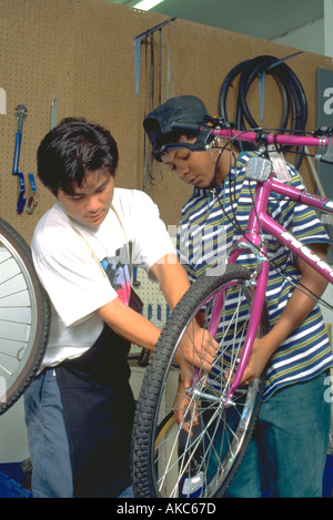 Arbeitnehmer mit 15 Jahren Befestigung Rad an Jugend Express Bike-Shop. St Paul Minnesota USA Stockfoto