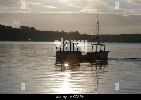 Ein Fischerboot verlässt Padstow Hafen in Cornwall, an der ersten Ampel Stockfoto