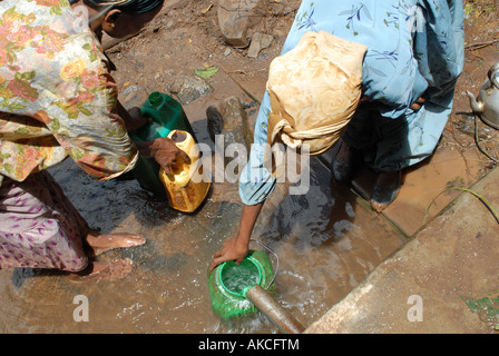 Äthiopische Frauen sammeln Wasser aus einer angeschnittene Ärmel Wasserquelle mit Haro, Äthiopien die Fairtrade-Prämie bezahlt Stockfoto