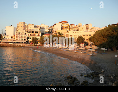 Kitroplatias Beach in Agios Nikolaos, in der Morgendämmerung im Sommer mit seinen Sonnenliegen bereit, den Tag s Urlauber zu empfangen. Stockfoto