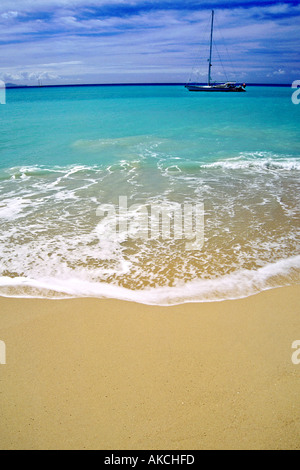 Ein Segelboot vor Anker in das türkisblaue Karibische Meer vor der Küste von Antigua. Stockfoto
