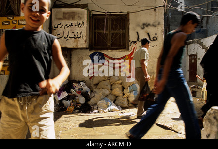 Ein Junge steht vor einer Wand mit anti-amerikanischen Amd anti-Israel-graffiti Stockfoto