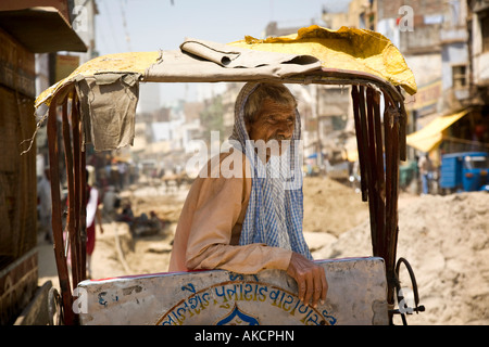 Porträt eines älteren Rikscha-Fahrer in einer heißen, staubigen Varanasi-Straße. Varanasi, Indien. Stockfoto