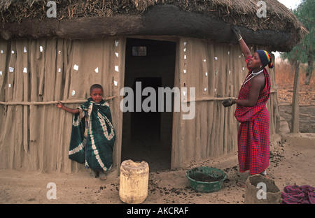 Masai Frau Verputzarbeiten Eingang und die Wände ihres Hauses mit Schlamm und Keramik Fragmente N Arusha auf dem Weg nach S-Kenia-Tansania Stockfoto