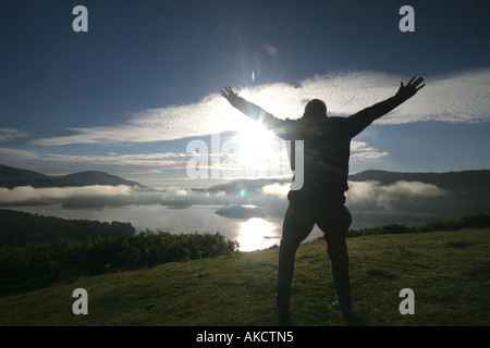 Ein stock Foto eines Mannes springen auf einem Berg bei Sonnenaufgang Stockfoto