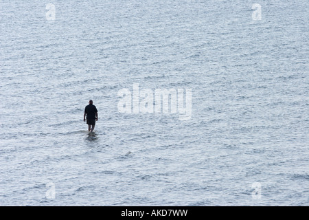 Einsame Figur geht auf einer Sandbank in den Gewässern der Nordsee in Büsum, Deutschland Stockfoto