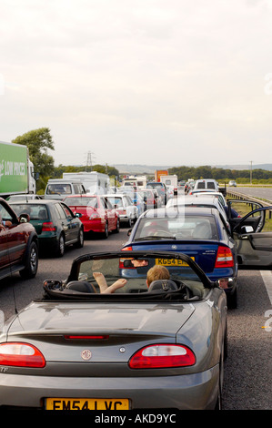 Große Verkehrsstaus auf der Autobahn M5, bei denen die Fahrer ihre Türen öffnen, um an warmen, bewölkten Sommertagen in Devon kühl zu bleiben. UK Stockfoto