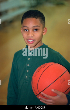 Schwarz Teen Alter 13 Holding Basketball Jugend Gemeindezentrum. St Paul Minnesota USA Stockfoto