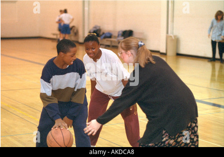 Teen Schüler 14 Jahre alt und Lehrer Alter von 28 Jahren Basketball spielen im Fitness-Studio. St Paul Minnesota USA Stockfoto