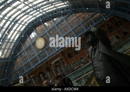 Skulptur von Sir John Betjeman in der Barlow-Schuppen mit St Pancras Uhr im Hintergrund Stockfoto