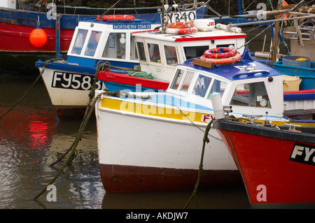 Nahaufnahme der farbenfrohen Bögen der angelegten Fischerboote im Hafen von Polperro. Cornwall, Großbritannien. Stockfoto