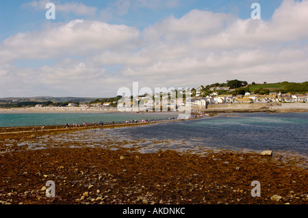 Touristen, die bei Ebbe den Damm entlang laufen, zum und vom St. Michael's Mount. Marazion, Cornwall, Großbritannien Stockfoto