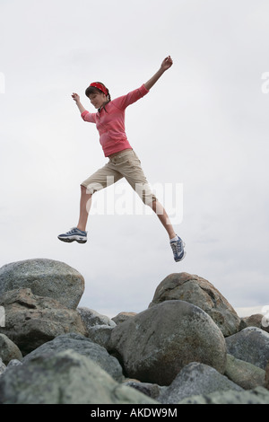 Frau mit Arme über Felsen springen Stockfoto