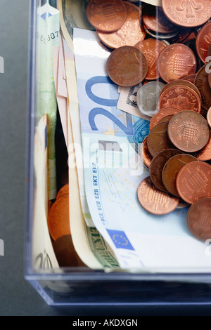 Kunststoff Sparschweinchen mit Münzen und Papier Euro-Währung, Ansicht von oben Stockfoto