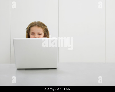 Kleines Mädchen vom Schreibtisch mit laptop Stockfoto
