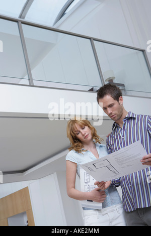Paar beobachten Plan im neuen Zuhause Stockfoto