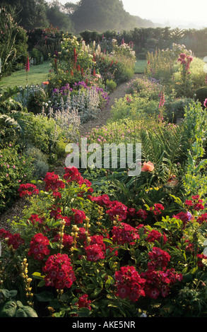 Frith Lodge Sussex Cottage-Garten grenzt an beiden Seiten von Kies Weg mit Bodendecker rose Rosa rote Decke Stockfoto