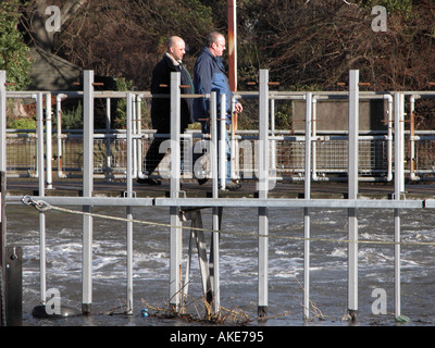 zwei Männer Kreuz ein Wehr auf der Themse in Hampton Stockfoto