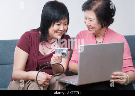 Nahaufnahme von einer reifen Frau und ein senior Frau sitzt mit einer Digitalkamera an einen Laptop angeschlossen Stockfoto