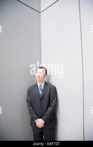 Geschäftsmann, stehen in einer Ecke mit seinen Händen umklammert Stockfoto