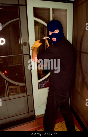 Ein Einbrecher rauben einem Haus eine Sturmhaube tragen. Stockfoto