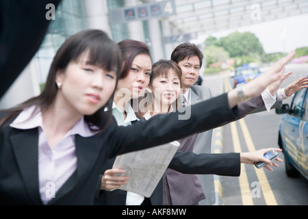 Geschäftsleute, die ein Taxi am Flughafen Stockfoto