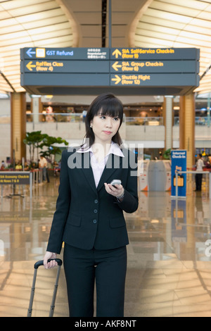 Geschäftsfrau, einen Flughafen verlassen und halten eines Handys Stockfoto