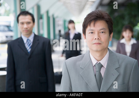 Porträt eines Geschäftsmannes mit drei Geschäftsleute im Hintergrund Stockfoto