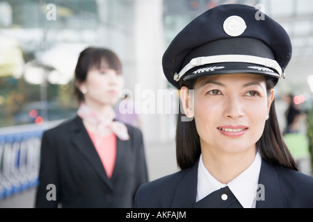 Eine weibliche pilot lächelnd mit einer weiblichen Flugbegleiter hinter ihr in Nahaufnahme Stockfoto