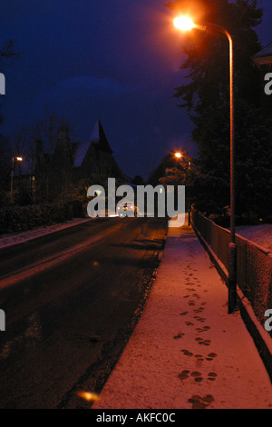 Schneebedeckte Straße und Gehweg an einem Winterabend in Malvern Stockfoto