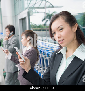 Zwei Unternehmerinnen mit einem Geschäftsmann in einer Flughafen-lounge Stockfoto