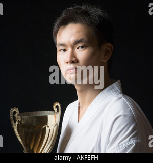 Porträt eines jungen Mannes hält eine Trophäe Stockfoto