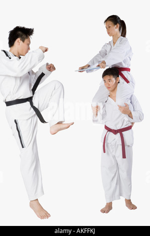 Mitte erwachsener Mann üben Kickboxen mit einem jungen Mann und eine junge Frau Stockfoto