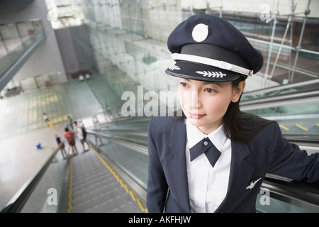 Nahaufnahme von einem weiblichen Piloten auf einer Rolltreppe Stockfoto