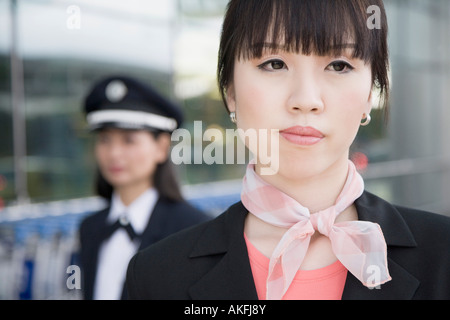 Nahaufnahme von einem weiblichen Flugbegleiter wegschauen mit einer Pilotin hinter ihr Stockfoto