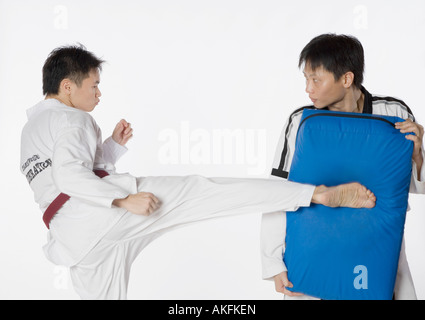 Männliche Karate-Lehrer unterrichten Kampfkünste zu einem jungen Mann Stockfoto