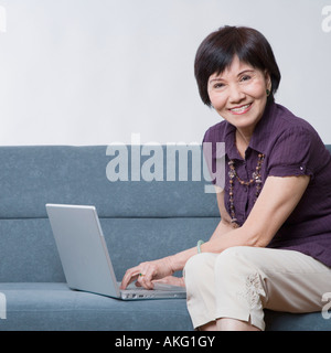 Porträt einer älteren Frau mit einem Laptop und lächelnd Stockfoto