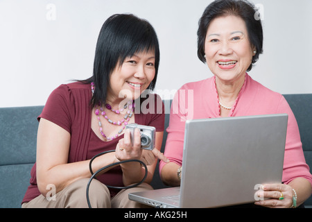 Porträt einer reifen Frau und ein senior Frau sitzt mit einer Digitalkamera an einen Laptop angeschlossen Stockfoto