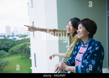 Seitenansicht einer älteren Frau stehend in einem Balkon mit ihrer Enkelin Stockfoto