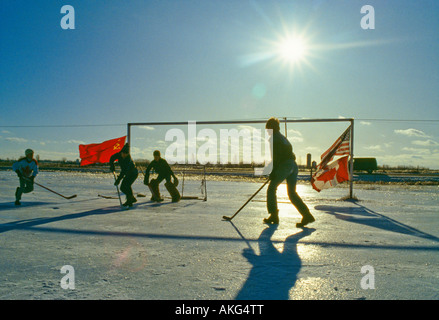 Jungen Pond Hockey Team Kanada, Russland, USA vier Jungs spielen Eishockey Teich auf einem Outdoor-ring Stockfoto